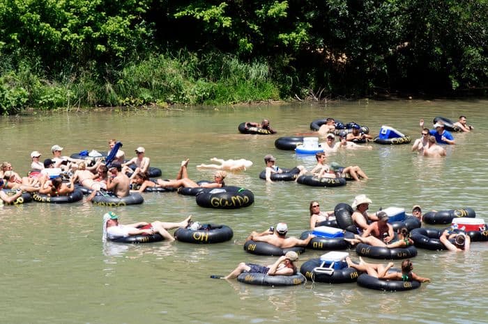 People at New Braunfels Camping Site Guadalupe River tubing together.