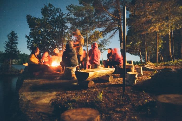People around a camp fire at night time at a New Braunfels camping site Guadalupe river.
