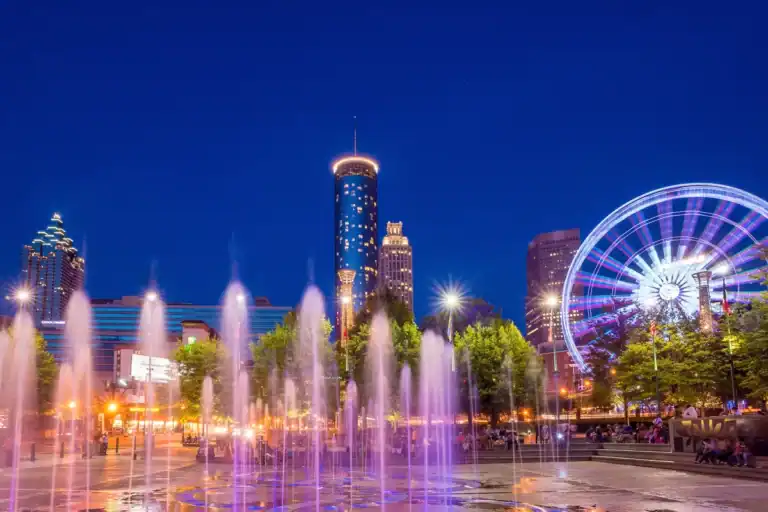 View from Centennial Olympic Park in Atlanta, Georgia at night with colourful lights and water spray.