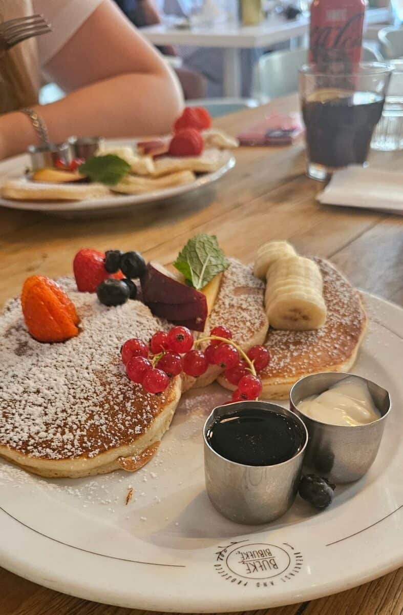 Fluffy pancakes with fresh fruit and syrup at Bułkę przez Bibułkę in Warsaw