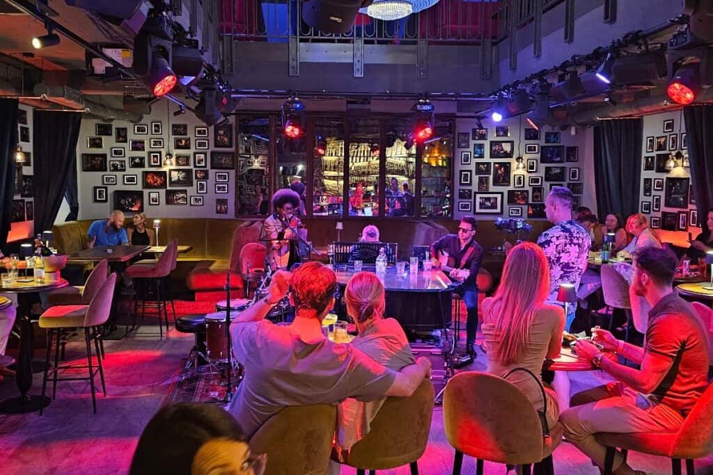 Live music performance at Piano Bar in Warsaw with couples and friends enjoying drinks.